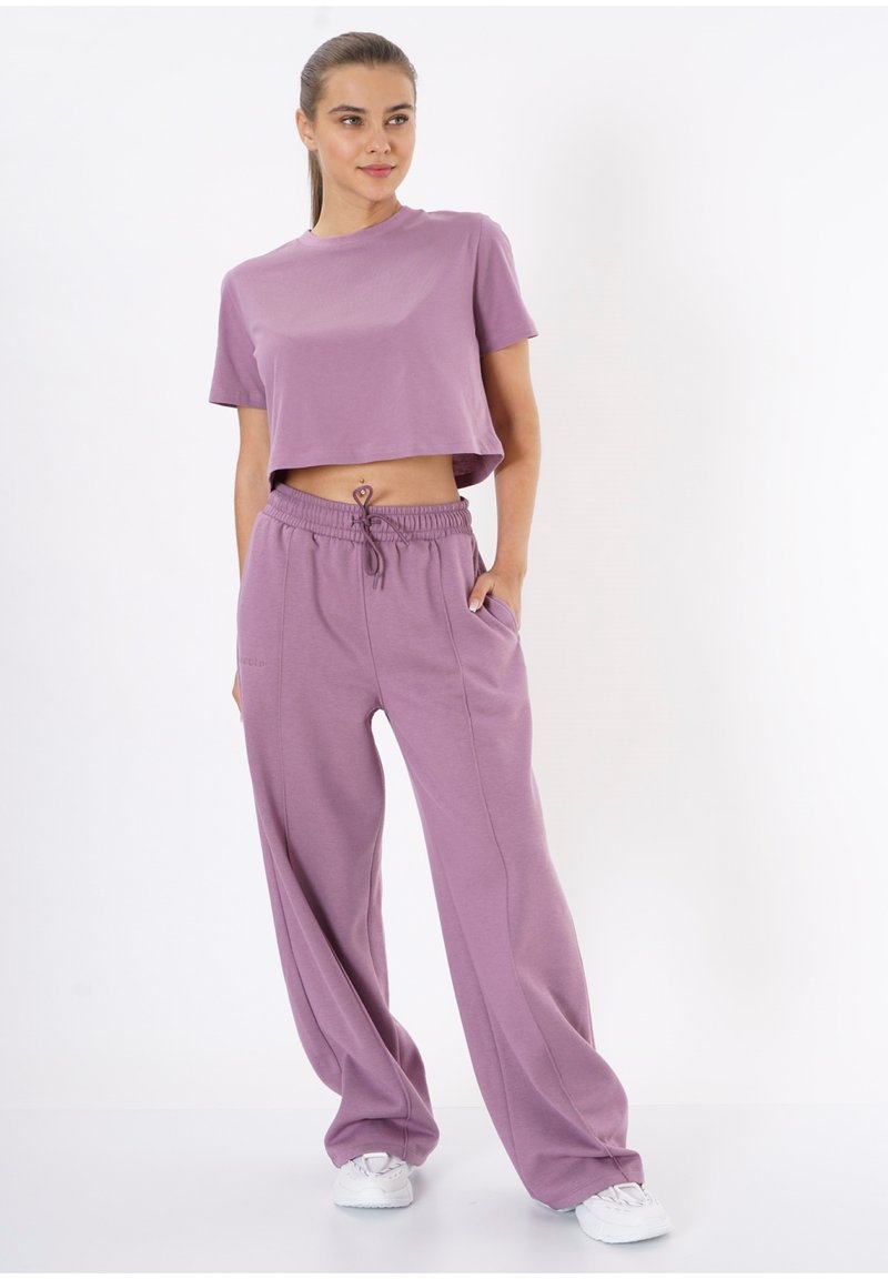 Light purple cropped t-shirt paired with loose-fitting light purple pants, featuring a drawstring waist and side pockets, made of soft fabric.