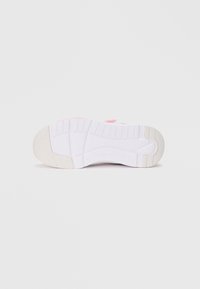 Semelle de sneaker blanche avec accent rose. Caoutchouc texturé pour l'adhérence, motif rainuré pour la flexibilité et zone de talon renforcée.