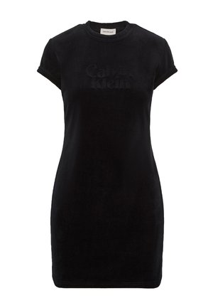 Vestido de terciopelo negro con mangas cortas, cuello redondo y logo en relieve "Calvin Klein" en el frente. Diseño ajustado, textura suave.