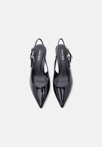 Μαύρα τακούνια slingback από γυαλιστερό δέρμα με μυτερή μύτη και ρυθμιζόμενο λουράκι με πόρπη. Διαθέτουν λείο υλικό και μινιμαλιστικό σχεδιασμό.