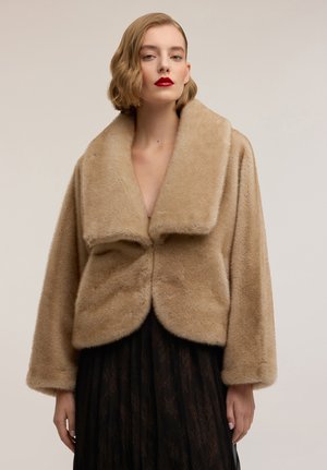 Giacca beige in pelliccia sintetica con ampio colletto, design corto e consistenza morbida. Presenta un orlo arrotondato e maniche a vestibilità rilassata.