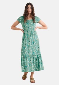 Rochie maxi verde cu model floral, cu mâneci scurte, un corset ajustat și un fustă cu volane. Fabricată dintr-un material ușor, cu nuanțe de alb și accente de albastru.