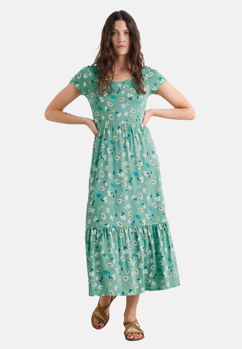Rochie maxi verde cu model floral, cu mâneci scurte, un corset ajustat și un fustă cu volane. Fabricată dintr-un material ușor, cu nuanțe de alb și accente de albastru.