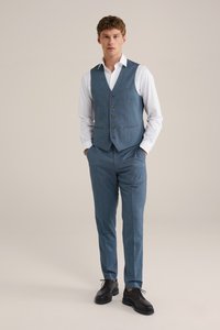 Saco de tres piezas para hombre que incluye un chaleco azul-gris ajustado con cinco botones, pantalones a juego y una camisa blanca. Unos zapatos negros completan el atuendo.