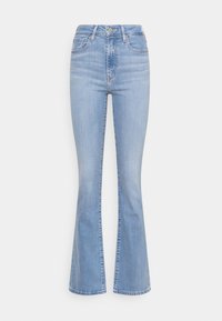 Jeans de mezclilla azul claro con campana y cintura alta, que cuentan con cinco bolsillos, un cierre de botón frontal y un ligero desgastado en la tela.