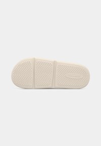 Cream-colored sneaker sole with herringbone pattern and three textured sections. Brand name "JACK&JONES" embossed on the surface.