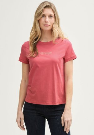 T-shirt à manches courtes en coton corail avec un col rond. Présente le texte du logo blanc "TOM TAILOR EST. 1962" centré sur la poitrine.