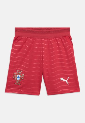 Rote Sportshorts mit dem Wappen der portugiesischen Nationalmannschaft auf dem linken Bein und weißem Puma-Logo auf dem rechten Bein, mit wellenförmigen horizontalen Streifen.