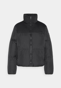 Chaqueta tipo puffer negra con cuello alto, cierre frontal con cremallera y textura acolchada. Presenta un panel superior mate en contraste y un sutil logotipo en el pecho.