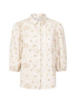 Witte blouse met gouden bloemenpatroon, knoopsluiting aan de voorkant, kraag en pofmouwen. Beschikt over textiel met een textuur en delicate borduursels.