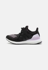 Black athletic shoe with a knitted upper, purple accents, three black stripes, and a white Boost midsole. Features textured patterns on the toe.