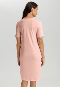 Abito rosa a maniche corte con una vestibilità comoda, bordo ondulato sulle maniche, realizzato in un tessuto morbido e leggero. Design semplice, lungo fino al ginocchio.