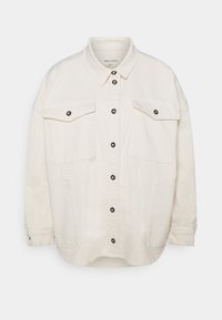 Beżowa, oversize'owa koszula-kurtka wykonana z bawełny, z przodem zapinanym na guziki, dwoma kieszeniami na piersi i czarnymi zatrzaskami. Posiada długie rękawy i zaokrąglony dół.