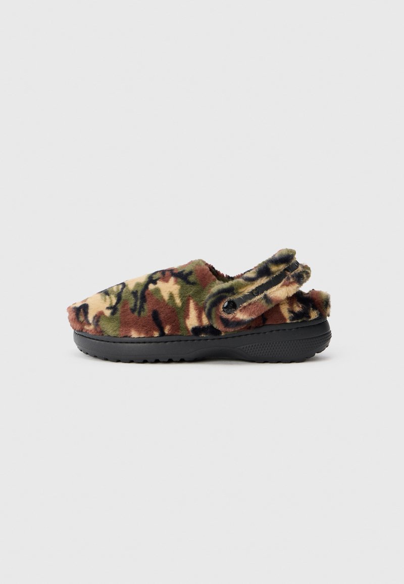 Sabots en fausse fourrure avec un motif camouflage vert, marron et noir et une sangle arrière réglable noire sur une semelle en caoutchouc noire.