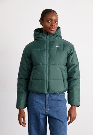 Green puffer jacket with a hood, zip closure, featuring a subtle pattern and Nike logo. Paired with blue jeans, smooth texture.