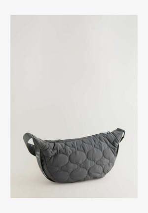 Czarna pikowana torba na ramię o zaokrąglonym kształcie, z zamkiem błyskawicznym i teksturowanym wzorem wypukłych kół; zawiera regulowany pasek.