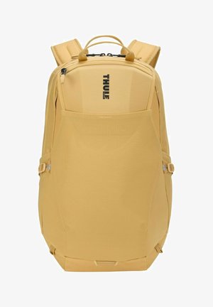 Gele Thule-rugzak met gevoerde schouderriemen, bovenhandvatten, voorvak met mesh en verticale ritssluiting op een witte achtergrond.