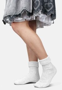 Baumwollsocken in einem hellgrauen Farbton mit gerippten Bündchen, die ein strukturiertes Strickmuster und eine lockere Passform um den Knöchel bieten.