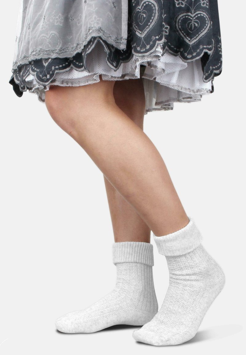 Baumwollsocken in einem hellgrauen Farbton mit gerippten Bündchen, die ein strukturiertes Strickmuster und eine lockere Passform um den Knöchel bieten.