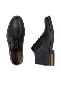 Zapatos de cuero negro con acabado suave, que cuentan con cordones y cremallera lateral, suela texturizada marrón y un sutil branding.