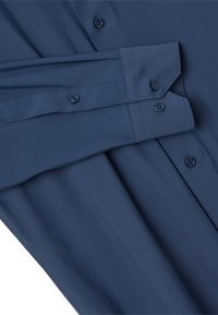 Camicetta a maniche lunghe blu navy realizzata in tessuto morbido, con colletto classico, chiusura a bottoni e vestibilità sagomata senza motivi visibili.