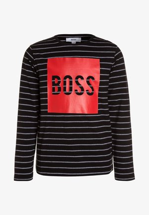 Maglia nera a maniche lunghe con sottili strisce orizzontali bianche e un grande quadrato rosso sul petto con la scritta "BOSS" in lettere nere grassetto.