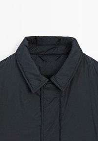 Dunkelblauer gepaddeter Jackenkragen mit aufstehendem Design. Glatte Textur, mit verdecktem Druckknopfdetail und verstärkten Nähten.