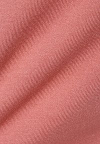 Rosa Stoff mit einer glatten, leicht strukturierten Oberfläche, die ein feines Rippmuster aufweist und Falten sowie Knicke zeigt.