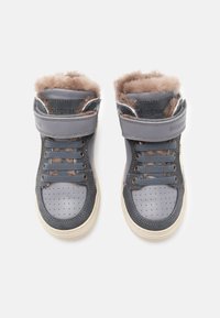Zapatos altos de color gris oscuro con forro de piel de zorro marrón suave, detalles perforados, puntera redonda, cordones en la parte delantera y una correa de gancho y bucle.