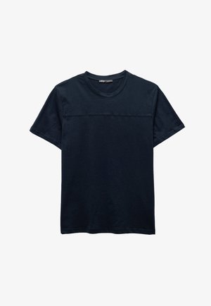 Camiseta de algodón azul marino con cuello redondo, mangas cortas y detalle de costura horizontal en el pecho. Textura suave y lisa.