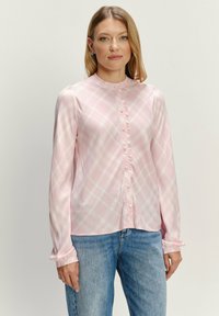 Langdrogige roze geruite blouse van soepel stof, met een mandarin-kragen, knoopsluiting aan de voorkant en elastische manchetten.