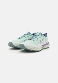 Scarpe da atletica leggere con una tomaia verde menta, design testurizzato, accenti viola e grigi, e suola in gomma resistente.