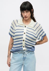 Suéter de manga corta tejido a rayas en azul y crema. Presenta un cuello con solapa y botones redondeados en la parte delantera. Diseño de tejido texturizado.