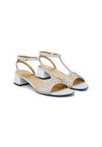 Weiße und goldene Sandalen mit einem T-Riemen-Design, verziert mit klaren Strasssteinen. Sie haben einen niedrigen Blockabsatz und eine offene Zehenpartie.