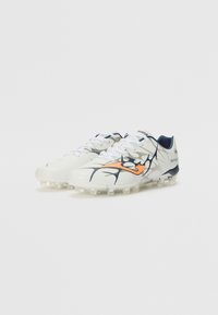 Botas de fútbol blancas con acentos en naranja y marino, que presentan un diseño texturizado, cierre de cordones y una parte superior con un patrón. Adecuadas para césped artificial.