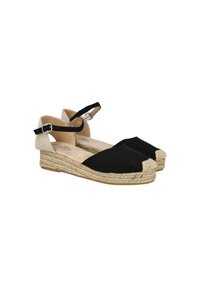 Sandalias espadrilles de lona negra con suelas cuña trenzadas beige, correas en el tobillo con hebillas plateadas y punteras cerradas.