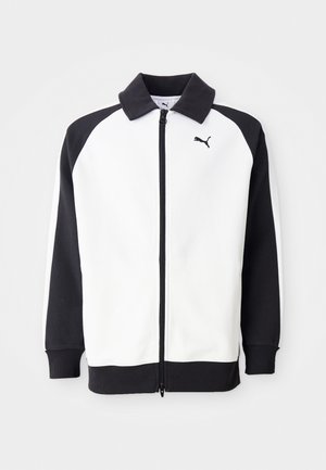 Puma trainingsjack met een witte body en zwarte raglanmouwen, met een ritssluiting en een zwarte kraag. Glad textuur, logo op de borst.