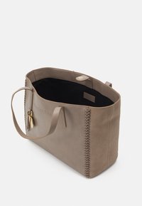 Grå læder tote bag med syede detaljer på siden, åben top og sort inderside. Har to håndtag og en lille guldhardware detalje.