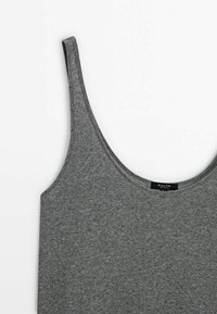 Débardeur gris côtelé avec un large décolleté et des bretelles fines. Confectionné dans un tissu doux et extensible, avec une étiquette près du col.