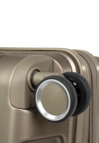 Bruine koffer met wielen, voorzien van een textuur oppervlak, metallic accenten en dubbele zwarte rubberen wielen voor soepele mobiliteit.