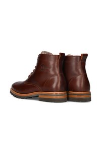 Bruine leren enkelboots met een gladde afwerking, ronde neus, veters en een contrasterende houten zool. Bevat een logo aan de buitenzijde.
