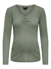 Langærmet grøn top med ribbet struktur, skåret halsudskæring, rynket detalje foran og tynde metalliske tråde i hele stoffet.