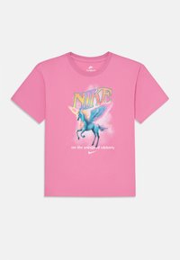T-shirt en coton rose avec un graphique d'une licorne bleue avec des ailes, le mot "NIKE" en gras jaune, et la phrase "sur les ailes de la victoire."