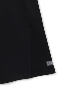 Shorts en coton noir avec une coupe droite, des coutures latérales et une étiquette indiquant "SLAY THE by keeping." Texture lisse, sans motifs visibles.