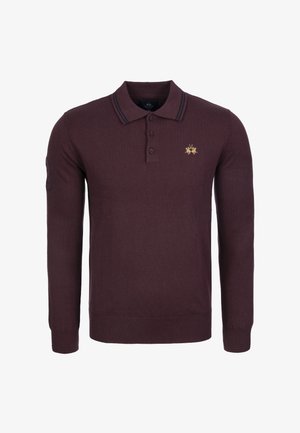 Polo à manches longues bordeaux en tissu tricoté. Il présente une patte de boutonnage à deux boutons, un col rayé et un petit emblème doré sur la poitrine.