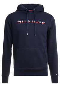 Sudadera navy con cordones, bolsillo frontal y logotipo bordado "HILFIGER NEW YORK" en rojo y blanco. Tejido suave y texturizado.