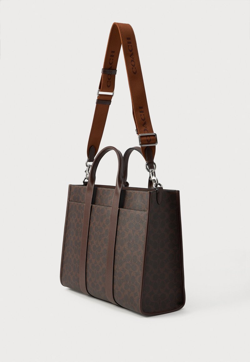 Borsa tote in pelle marrone con esterno a pattern, doppi manici superiori e una tracolla regolabile con marchio "COACH".