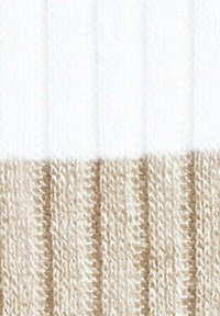 Strickstoff mit einer gerippten Textur, bestehend aus zwei horizontalen Abschnitten: oben weiß und unten beige.