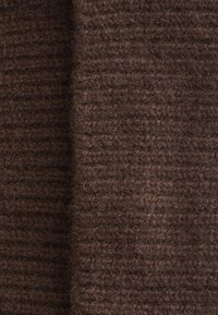 Brown knit fabric with a textured, ribbed pattern. The material appears soft and fuzzy, showcasing rich, natural fibers.