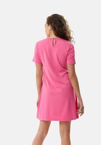 Pink short-sleeve dress in a soft, smooth fabric. Features a keyhole back detail and a relaxed, A-line silhouette.